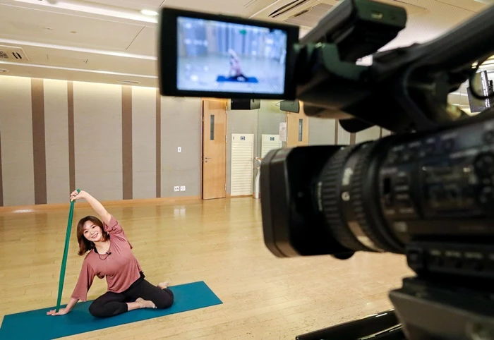 13일 현대백화점 무역센터점 문화센터 강의실에서 김은아 필라테스 강사가 ‘밴드필라테스 홈트레이닝 스트레칭’ 강좌를 카메라 등 중계 장비 앞에서 선보이고 있다. / 사진=현대백화점그룹 제공