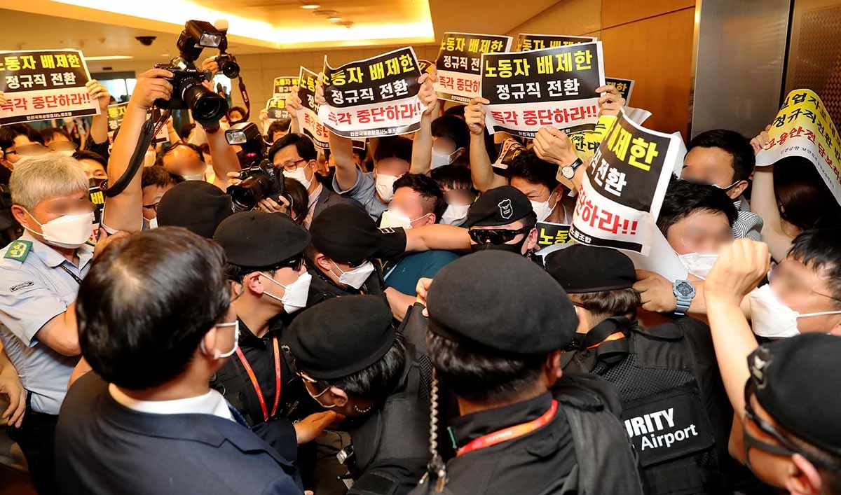 구본환 인천국제공항공사 사장이 22일 오후 인천공항1터미널에서 열린 기자회견에서 정규직 전환에 대한 입장을 밝히고 퇴장하자 노동자들이 정규직 전환을 반대하는 노동자들이 항의를 하고 있다. 인천공항공사는 22일 인천공항 보안요원 1900여명을 정규직화 한다고 밝혔다 / 뉴스1