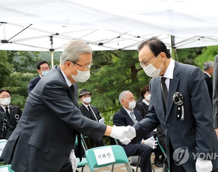 김종인 미래통합당 비상대책위원장(왼쪽)과 이해찬 더불어민주당 대표가 18일 국립서울현충원에서 열린 고 김대중 전 대통령 서거 11주기 추도식에서 만나 악수를 나누고 있다