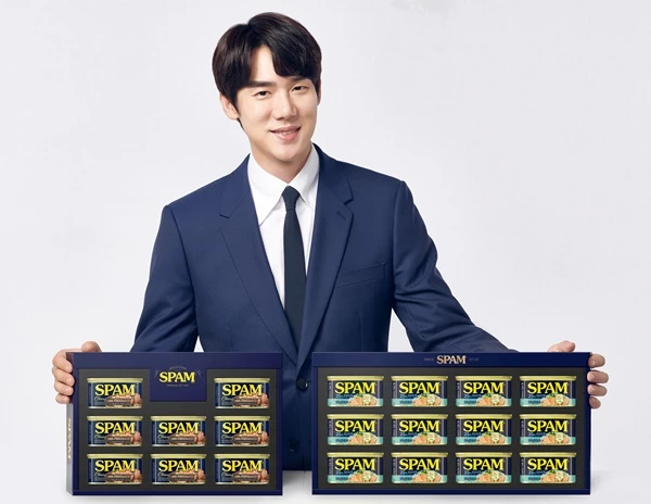 CJ제일제당 '스팸' 모델 배우 유연석이 플라스틱 캡을 제거한 스팸 선물세트 2종을 선보이고 있다. / 사진=CJ제일제당 제공