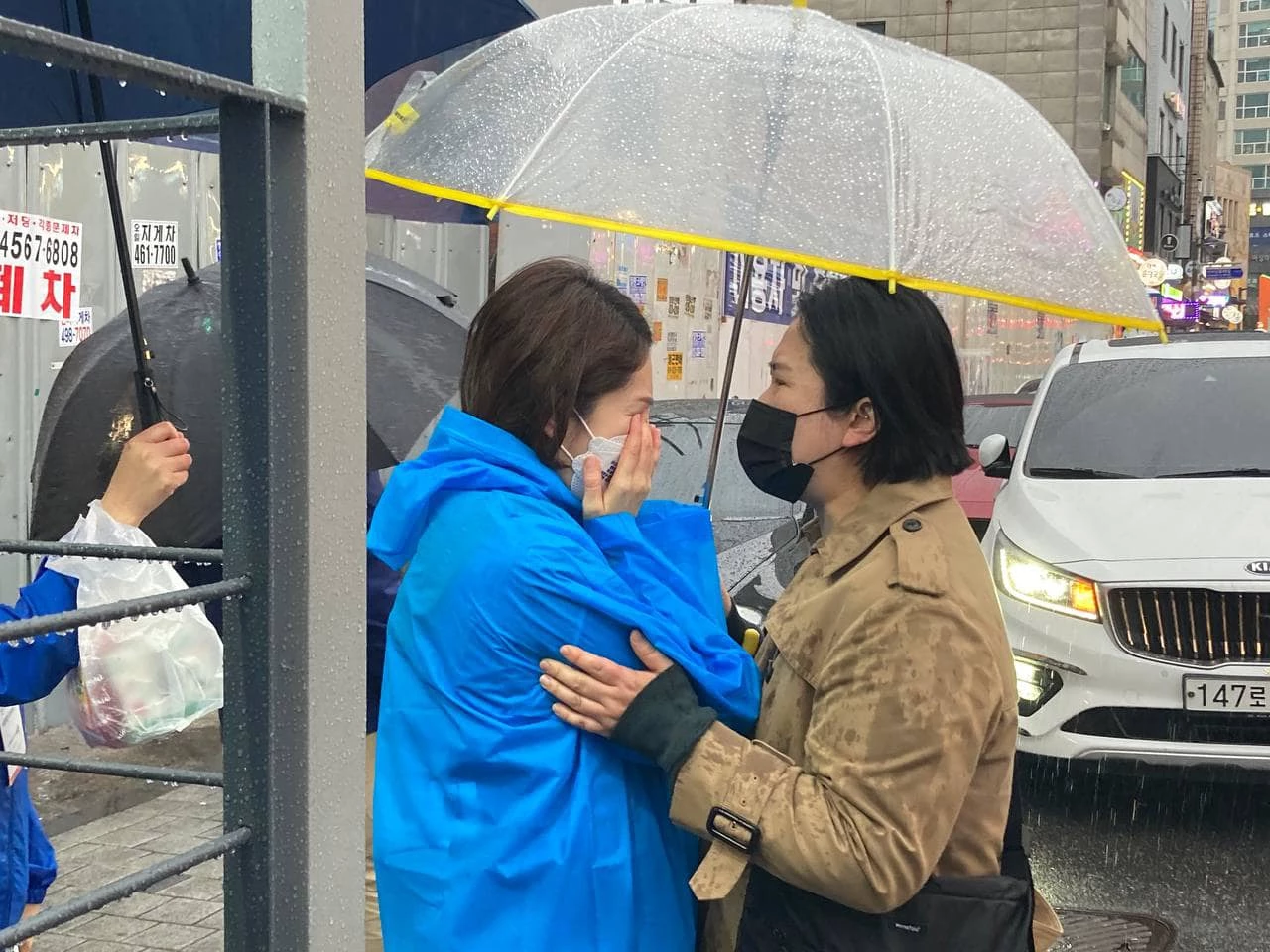 고민정 더불어민주당 의원이 한 시민과 만나 울고 있다.