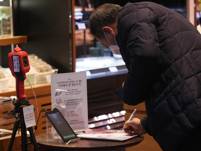 한 카페에서 출입 명부를 작성 중인 시민의 모습