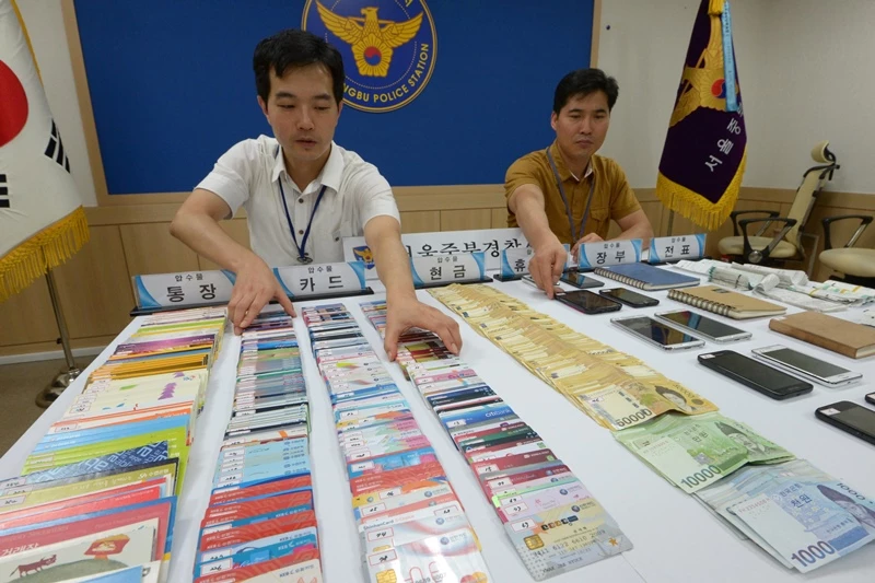 서울 중부경찰서 경찰관들이 스미싱 등으로 3개월간 1억여원을 편취한 일당으로부터 압수한 물품을 공개하고 있다. / 뉴스1