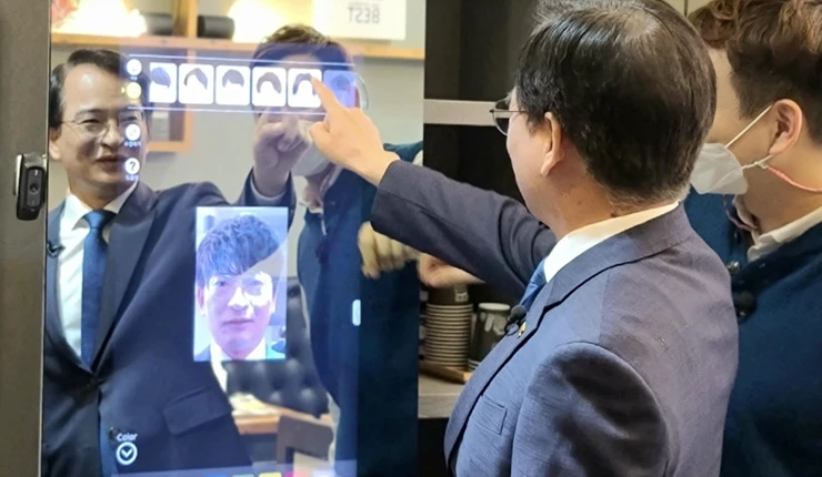 김삼호 광산구청장이 지난 4월 스마트 상가 시범사업이 추진된 한 미용실을 찾아 스마트 미러를 체험하고 있다.