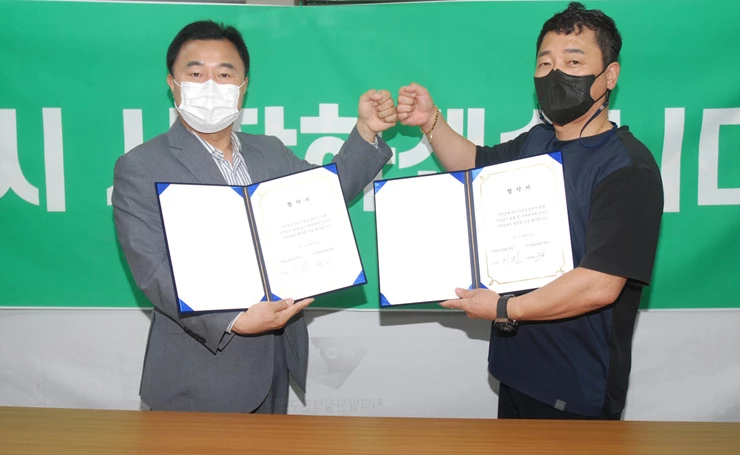 이진 후보와 서민창업경영지원단 김석수 정책실장이 업무협약서를 교환하고있다.