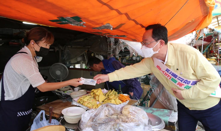 명현관 해남군수가 해남사랑상품권을 이용한 전통시장 장보기를 하고있다.