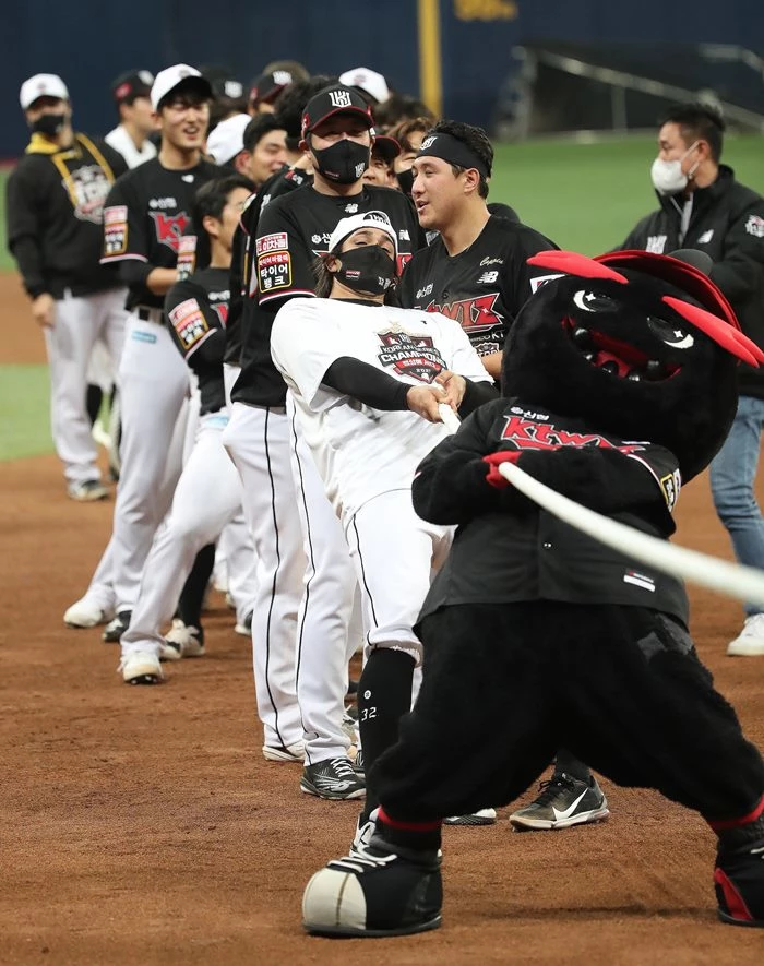 18일 오후 서울 구로구 고척스카이돔에서 열린 '2021 신한은행 쏠 KBO 한국시리즈’ 4차전 kt wiz와 두산 베어스의 경기에서 승리하며 한국시리즈 우승을 거머쥔 KT 선수들이 팬들과 함께 오징어게임의 줄다리기 세리머니를 하고 있다