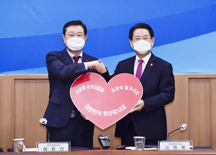 김영록 전라남도지사와 이용섭 광주시장 3일 오후 광주시 서구 치평동 김대중컨벤션센터에서 양 시도가 공동으로 추진할 초광역 협력사업 등을 논의하기 위해 열린 광주ㆍ전남 상생발전위원회에서 ‘군공항 국가사업화ㆍ초광역 메가시티 대한민국 영산강시대’가 적힌 하트모양 피켓을 들고 기념촬영을 하고 있다.    / 광주시