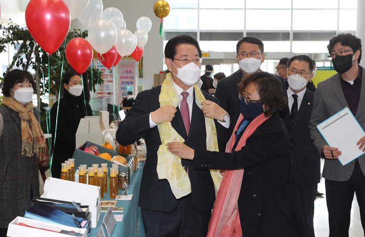 김영록 전라남도지사가 15일 도청 윤선도홀에서 열린 ‘관광두레·스타트업 깐부데이 페스타’ 행사에서 관광 로컬기업에서 생산한 판매물을 구입해 착용해 보고 있다.