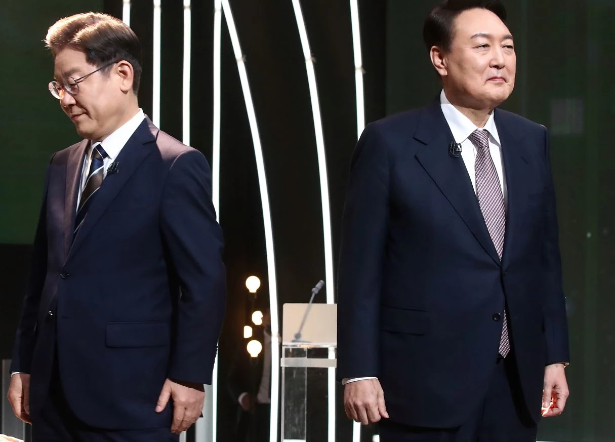 3일 오후 서울 여의도 KBS 공개홀에서 열린 <방송 3사 합동 초청> 2022 대선후보 토론에서 이재명 더불어민주당 대선 후보가 기념촬영을 마친 뒤 자리로 돌아가고 있다. 오른쪽은 윤석열 국민의힘 대선 후보 / 이하 뉴스1