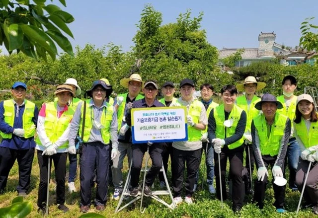 농촌 일손돕기 봉사활동에 참여한 기술보증기금 직원들이 단체 기념사진을 촬영하고 있다. / 사진제공=기보