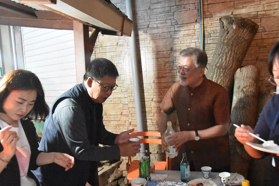 문재인 전 대통령이 마을주민과 막걸리를 곁들인 식사를 하고 있다. / 문 전 대통령 페이스북