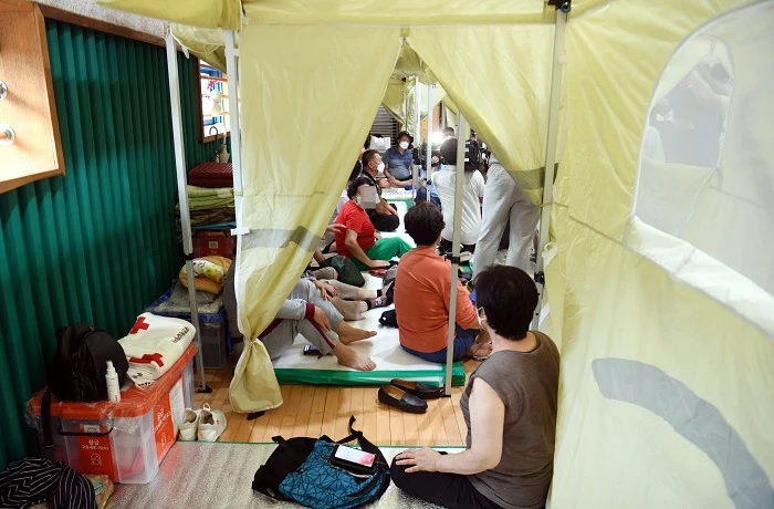 구룡마을 이재민들이 지난 10일 임시대피소인 구룡중학교 체육관을 찾은 박홍근 더불어민주당 원내대표 등 지도부들의 수해복구 대책에 귀기울이고 있다. / 뉴스1