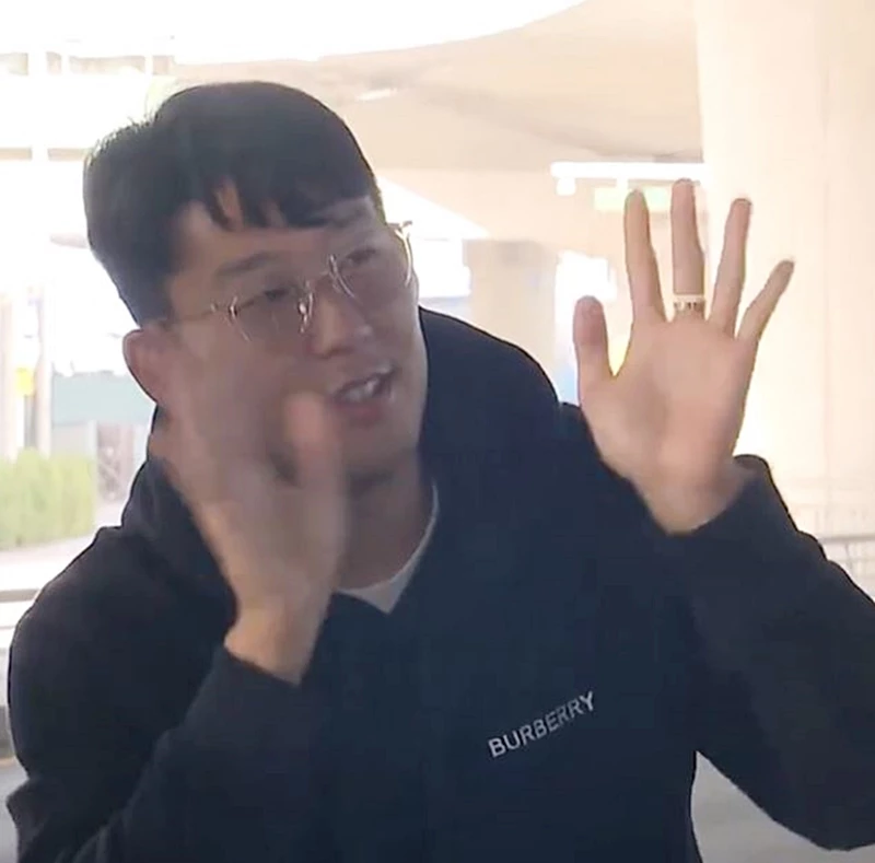 마지못해 차량 밖으로 나와 취재진에게 인사하는 손흥민