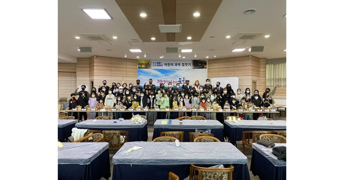 포항건축문화제 체험행사인 어린이 과자 집짓기에 참여한 부모와 아이, 참석 내빈들이 파이팅을 외치고 있다 / 포항시 제공