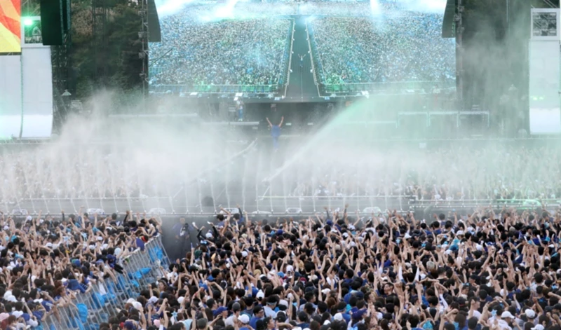 싸이의 대표 여름 공연 '흠뻑쇼'의 모습. 사진은 2018년 공연 때로, 관객들이 쏟아지는 물줄기를 맞으며 콘서트를 즐기고 있다.