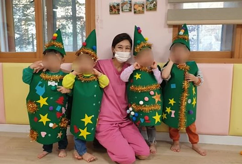 입양원 아이들과 크리스마스트리 옷을 만든 김하늘이 기념사진을 남기고 있다.