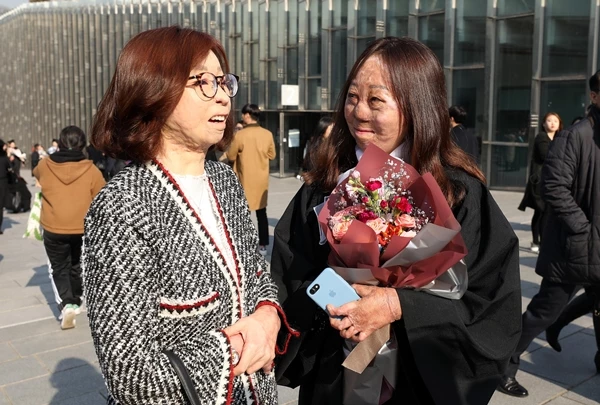 2018년 2월 26일 서울 서대문구 이화여자대학교에서 열린 학위수여식에서 화마 딛고 희망을 전하는 한동대 상담심리사회복지학부 교수로 재직 중인 이지선 동문이 전신화상의 아픔을 이겨내고 지난 4년간 학업에 매진해 학사모를 쓰게 된 최려나 학생의 졸업을 축하해주고 있다. 중국 국적인 최려나 학생은 11살 때 불의의 사고로 전신 95%에 3도 화상을 입었다. 이후 40여 차례의 수술을 받으면서도 꾸준히 공부해 2014년 영어영문학전공에 입학, 화제가 됐다. / 뉴스1