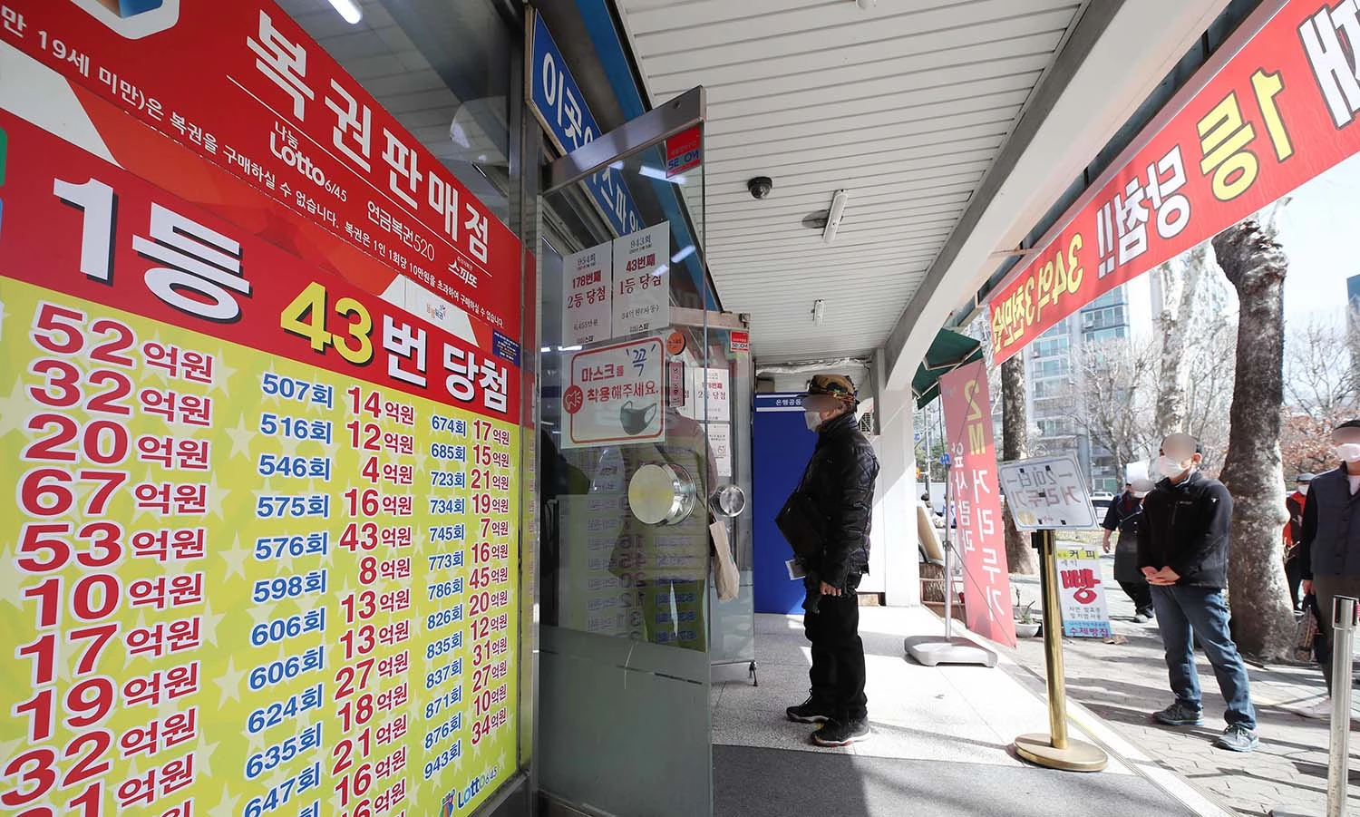 2021년 3월 16일 오전 서울 노원구의 복권판매점 앞에 복권을 사기 위한 시민들이 줄을 서 있다.  / 뉴스1