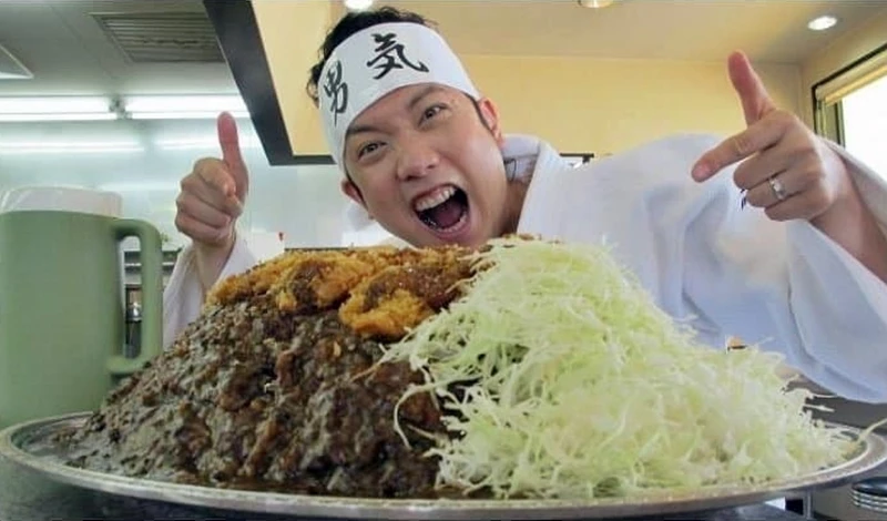 한 남성이 10kg 돈가스 카레 완식 챌린지에 앞서 인증샷을 찍고 있다. /디시인사이드