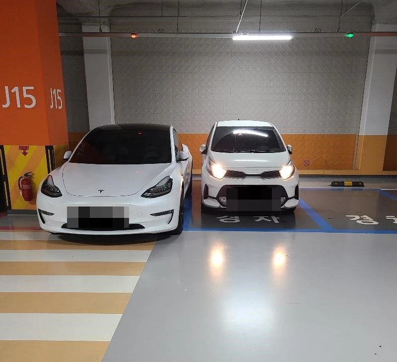 사연자 A씨가 지난달 30일 온라인 커뮤니티 보배드림에 테슬라와 나란히 경차 주차 구역에 차량을 세워 둔 모습을 공개했다. / 이하 온라인 커뮤니티 보배드림