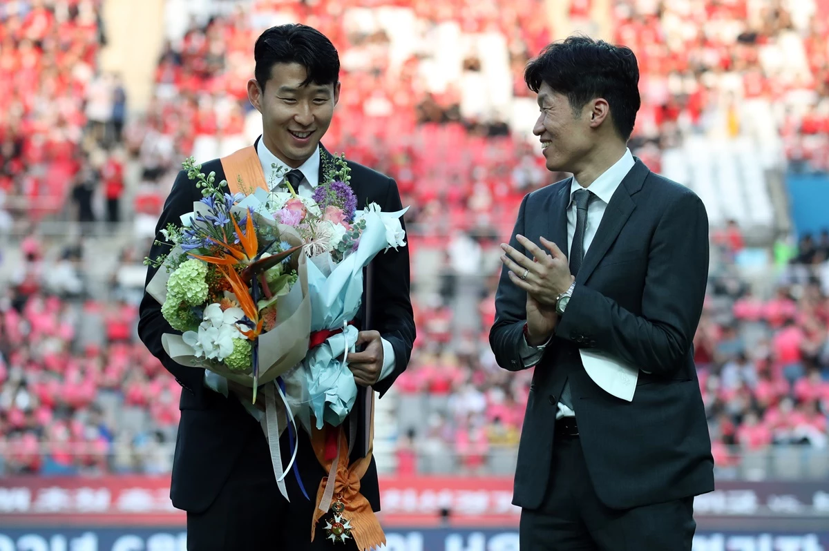잉글랜드 프로축구 프리미어리그(EPL)에서 아시아 선수 최초로 득점왕을 차지한 손흥민이 2일 서울월드컵경기장에서 2002 한일월드컵 20주년 기념 평가전 대한민국-브라질의 경기에 앞서 윤석열 대통령으로부터 체육훈장 최고등급인 청룡장을 수여받은 뒤 박지성에게 축하받고 있다.