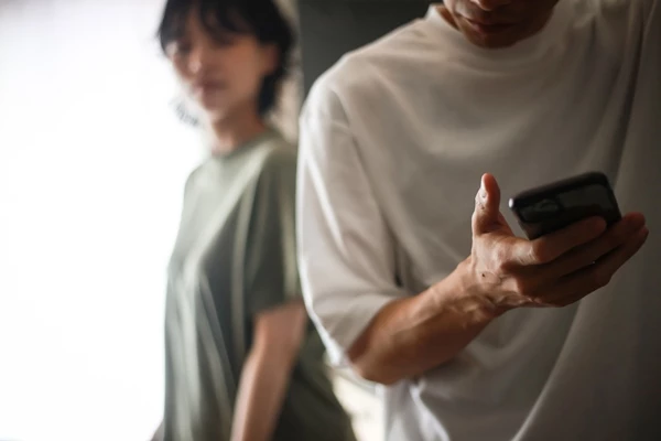 한 남성이 핸드폰 만지는 걸 연인이 의심하고 있다. ((기사 이해를 돕기 위한 이미지) / yamasan0708-shutterstock.com
