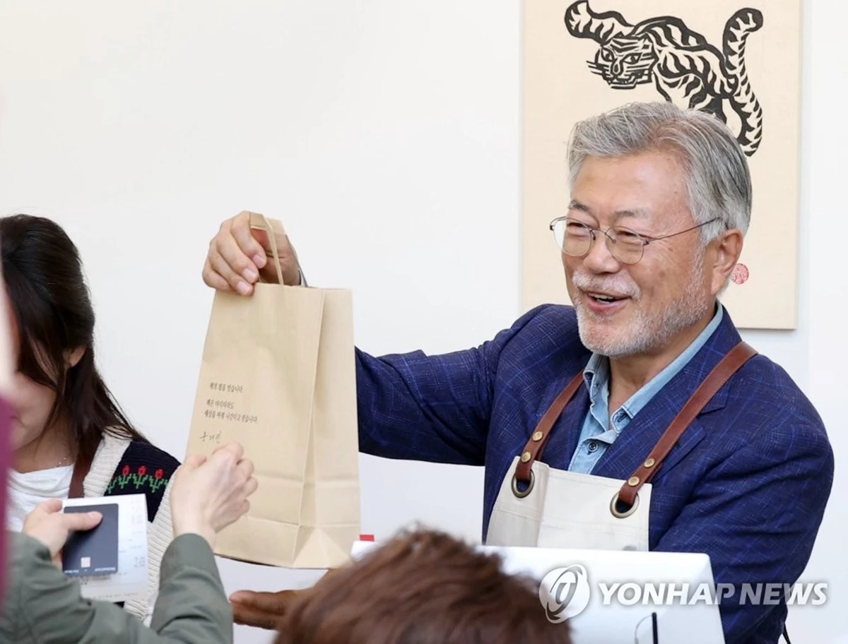 평산책방 손님에게 판매한 책을 건네는 문재인 전 대통령