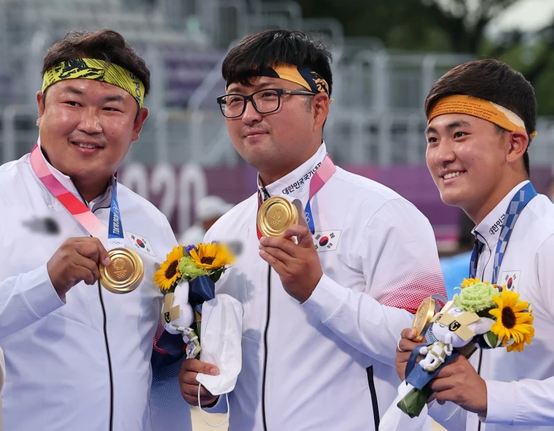 2021년 7월 열린 2020 도쿄 올림픽 양궁 남자단체전 시상식에서 금메달을 들고 포즈를 취하는 (왼쪽부터) 오진혁, 김우진, 김제덕 선수