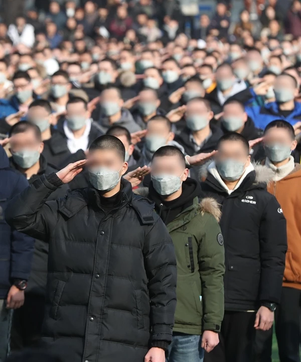 2019년 입영장병들이 거수경례를 하며 가족들과 작별 인사를 하고 있다. / 이하 뉴스 1