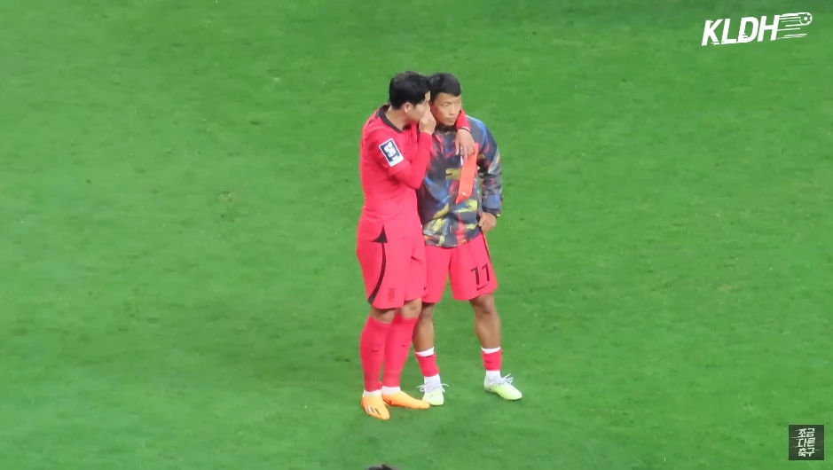 황희찬에게 귓속말로 뭔가를 전달하는 손흥민