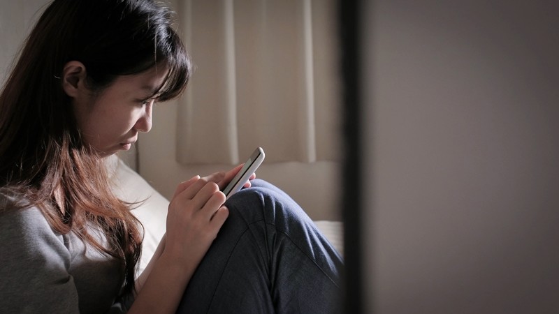 휴대폰 화면을 보며 슬픔에 잠긴 여성 (참고 사진)