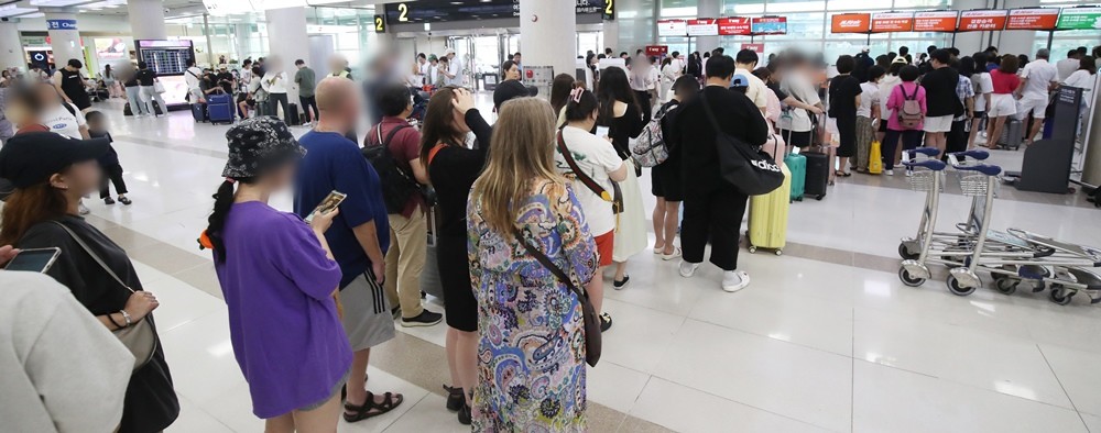 제6호 태풍 카눈이 북상 중인 지난 9일 오전 제주국제공항에서 결항편 승객들이 대체편을 구하기 위해 항공사 안내 데스크 앞에 길게 줄을 서 있다.