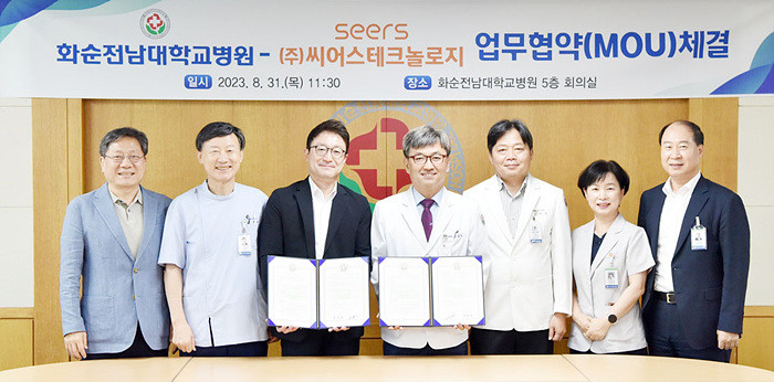 화순전남대학교병원 정용연 병원장(오른쪽에서 네 번째)과 ㈜씨어스테크놀로지 이영신 대표(왼쪽에서 세 번째)가 협약서에 서명 후, 참석자들과 기념촬영을 하고 있다.