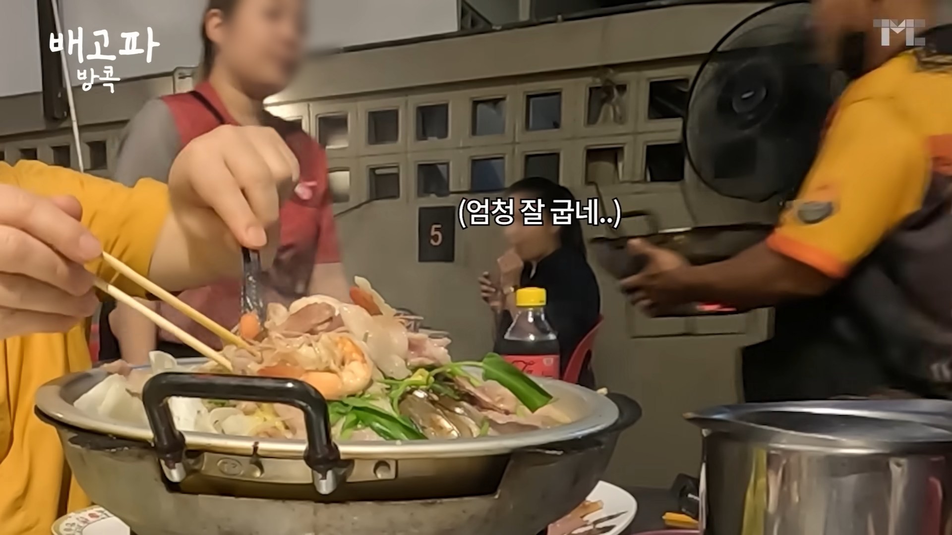 백종원이 무까타를 조리하는 장면을 바라보는 현지 손님의 모습에 '엄청 잘 굽네'라는 자막이 달려 있다. / 유튜브 '백종원 PAIK JONG WON'