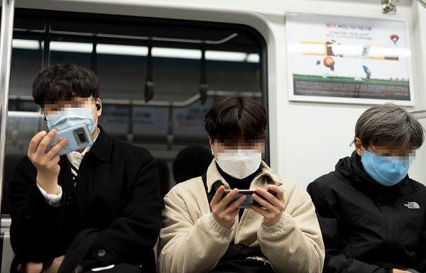 지하철에서 휴대전화를 보고 있는 남성 자료사진 / LegoCamera-Shutterstock.com