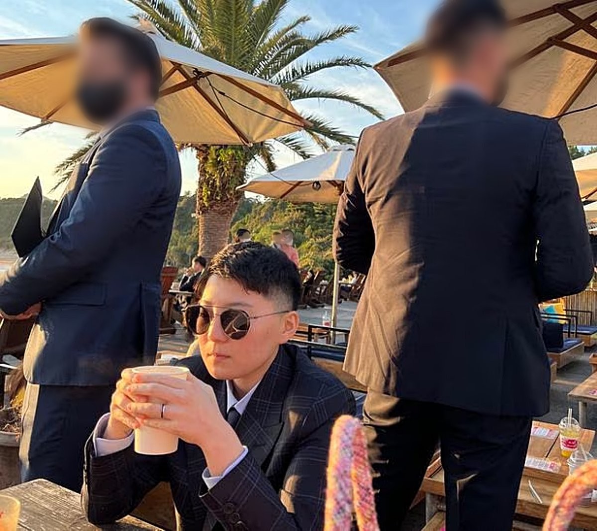 김민석 서울 강서구의원이 제공한 전청조 제주도 목격 사진. 한 카페 야외에 앉아 음료를 마시는 전청조(가운데) 양옆으로 경호원으로 추정되는 남성 2명이 서 있다. / 김민석 서울 강서구의원 제공