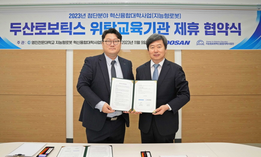 박응서 두산로보틱스 남부지사장(왼쪽)과 안상욱 영진전문대 지능형로봇사업단장이 협동로봇 위탁교육기관 제휴 협약 후 기념촬영을 하고 있다.  / 영진전문대학교 제공