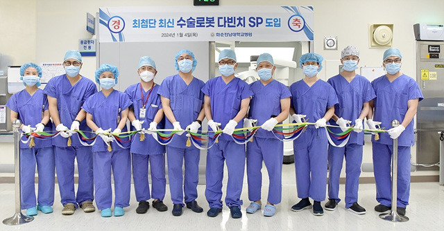 정용연 병원장(왼쪽에서 여섯 번째) 등 화순전남대병원 임원진과 의료진들이 1월 4일 수술실에서 열린 수술 로봇 다빈치 SP 도입 행사에서 테이프 커팅을 하고 있다.