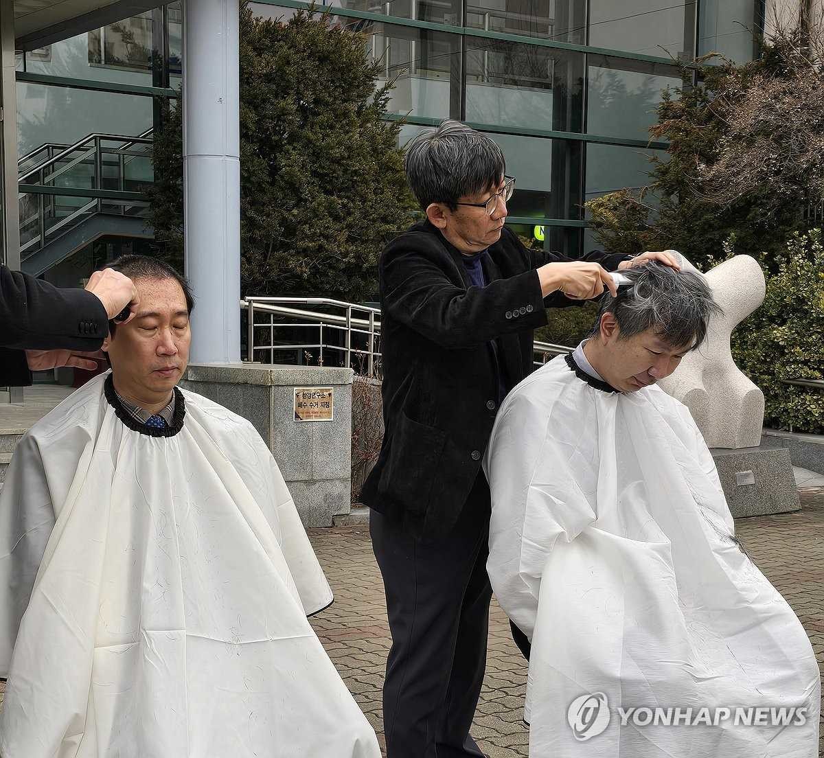 5일 오전 강원대학교 의과대학 앞에서 의대 교수들이 삭발식을 열고 대학 측의 증원 방침에 반발하고 있다. / 강원대학교 의대 교수진 제공-연합뉴스