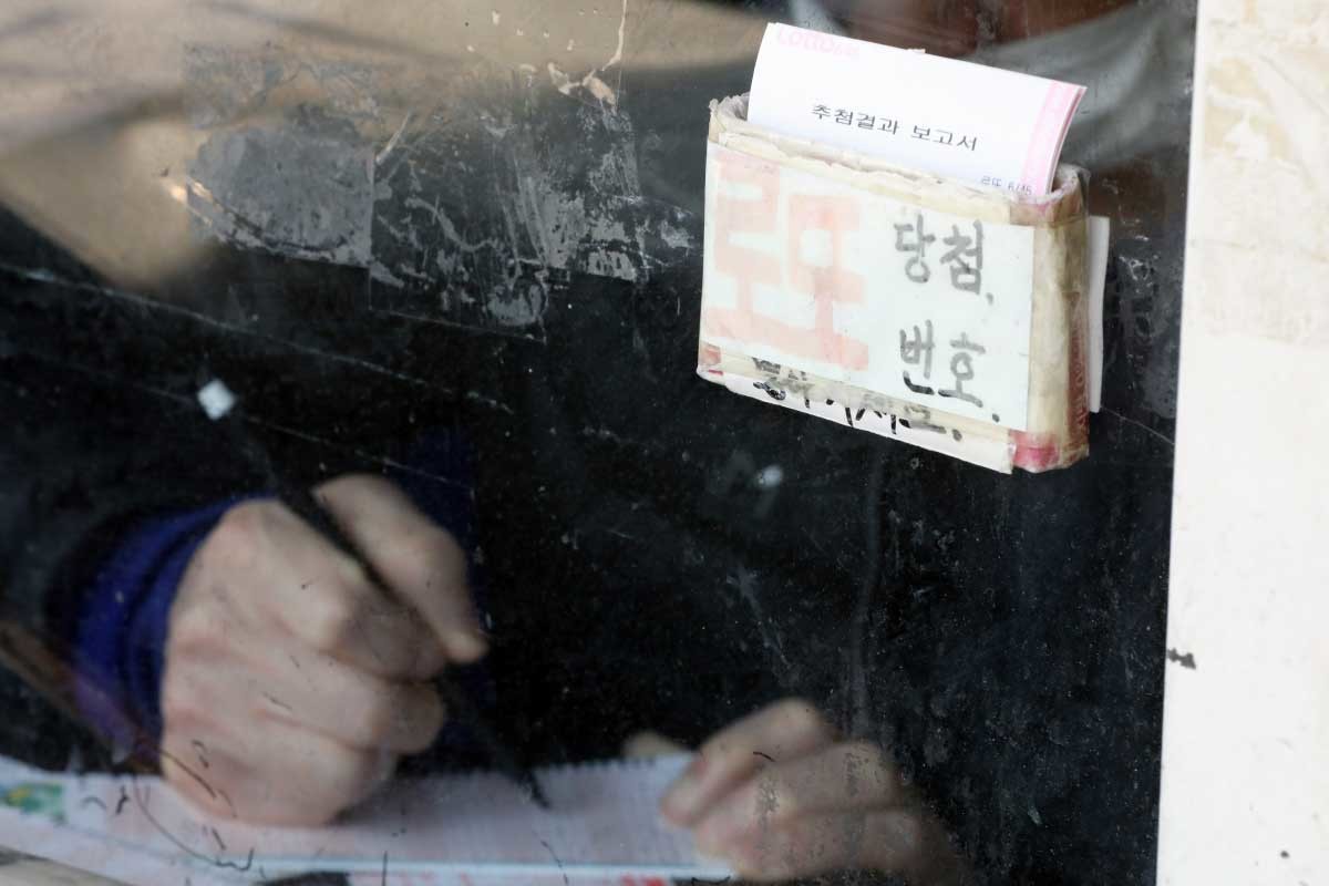 서울 동대문구의 복권판매점에서 한 시민이 로또 번호를 기입하고 있다. / 뉴스1