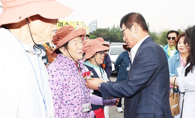 이상익 함평군수가 어르신께 카네이션을 달아들이고 있다.
