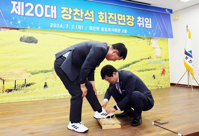 김성 장성군수가 장찬석 면장에게 운동화를 선물하며, 발로뛰는 현장행정을 강조했다.