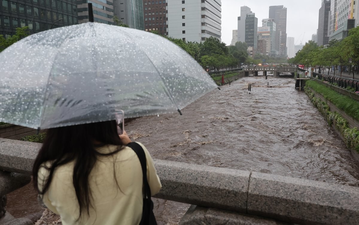 폭우로 물에 잠긴 청계천을 바라보는 시민 / 뉴스1
