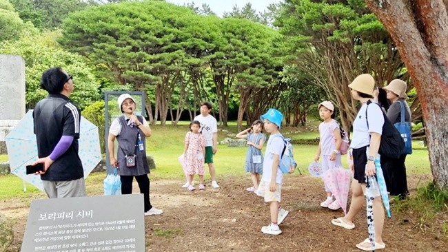 한하운 시인의 보리피리 시비 앞에서 해설을 듣고 있는 학생, 학부모들