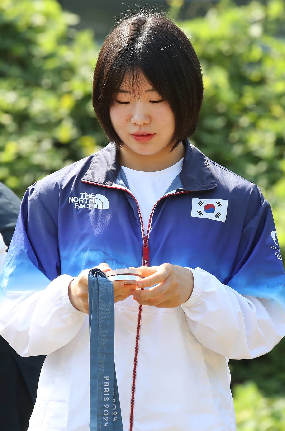 2024 파리 올림픽에서 개인전 은메달과 단체전 동메달을 딴 유도 대표팀 허미미(경북체육회)가 6일 오전 대구 군위군 삼국유사면 화수리에 마련된 독립운동가이자 현조부인 허석 지사의 추모기적비를 찾아 참배를 앞두고 메달을 바라보고 있다 / 뉴스1