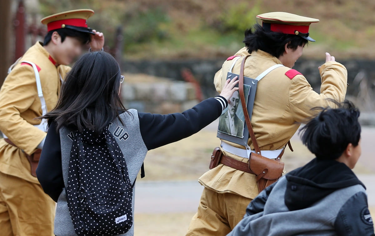 2015년 제76회 순국선열의 날(11월 17일)을 앞두고 8일 오후 서울 현저동 서대문형무소역사관에서 열린 '순국선열 구출 작전' 행사에 참가한 학생들이 일본 순사 복장을 한 배우들의 등에 부착된 순국선열 초상화를 떼어내기 위해 쫓고 있다. / 연합뉴스