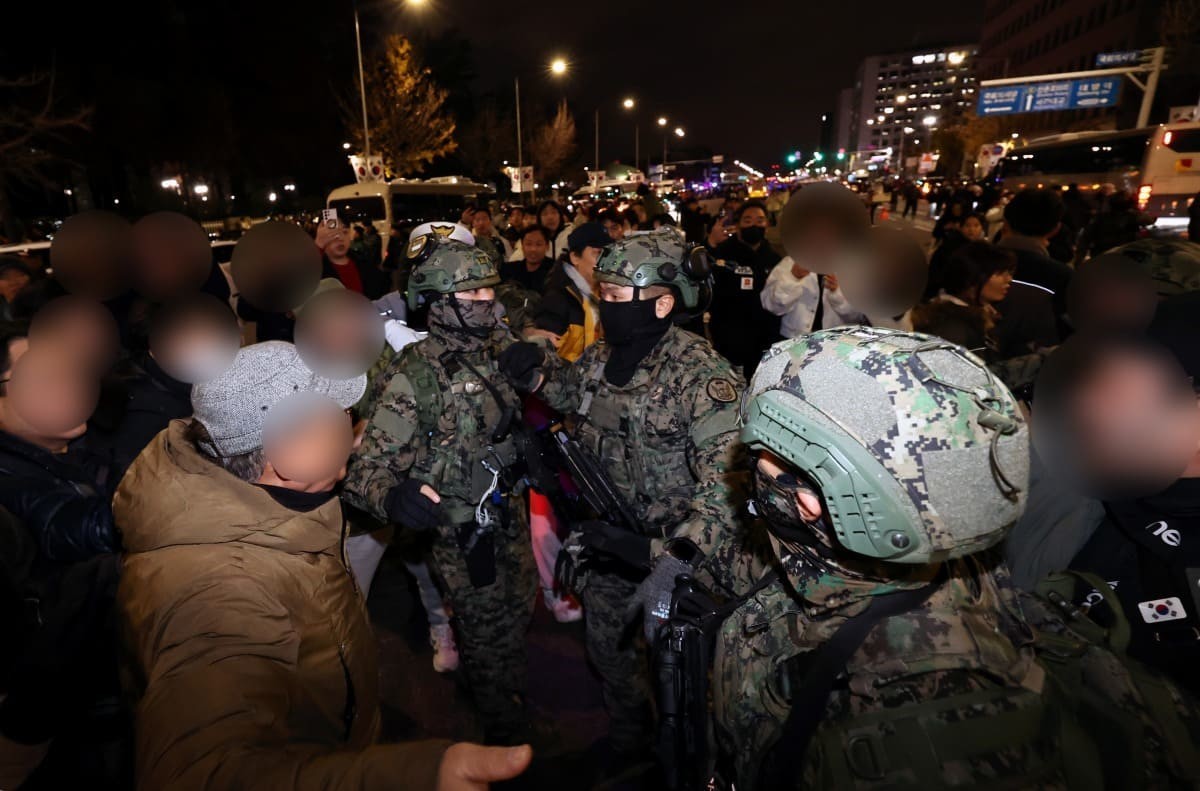Amid President Yoon Suk Yeol’s sudden declaration of martial law, citizens in front of the National Assembly in Yeouido, Seoul, block martial law soldiers attempting to enter the premises in the early hours of December 4. / News1