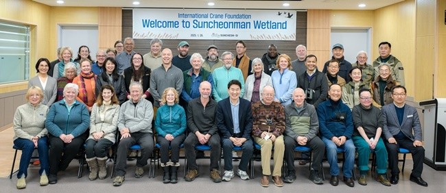 순천만습지를 방문한 국제두루미재단 임원들이 시 관계자들과 기념사진을 찍고 있다.