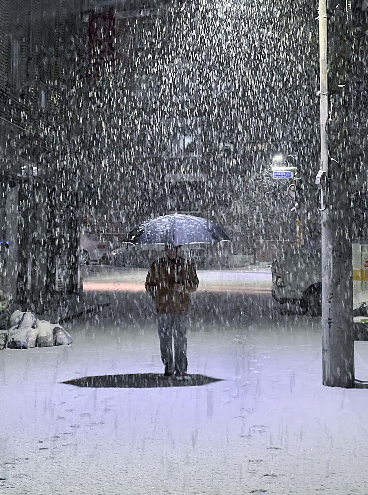 설 명절 연휴 사흘째이자 대설특보가 발효된 27일 밤 서울 송파구 거리에서 시민이 쏟아지는 눈발을 헤치며 발걸음을 재촉하고 있다.  / 뉴스1